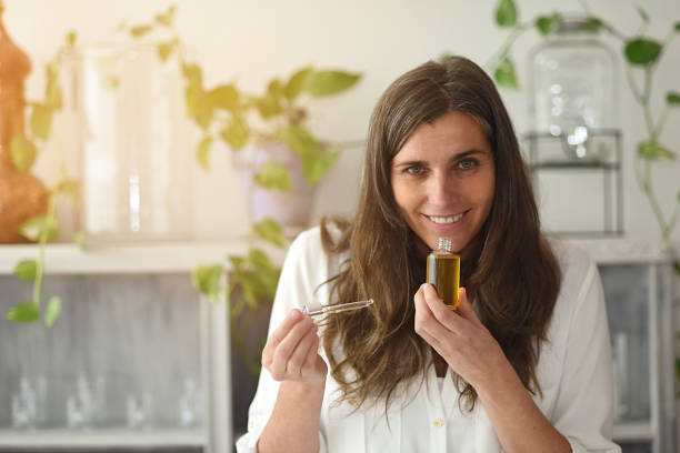 istock Woman with open Serum-elixir bottle enjoying its aroma 1296703414