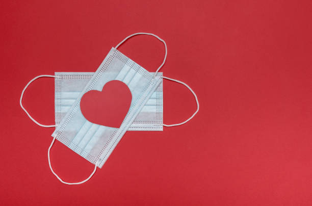 istock Red background. Medical protective masks. And a red heart. 1296703418