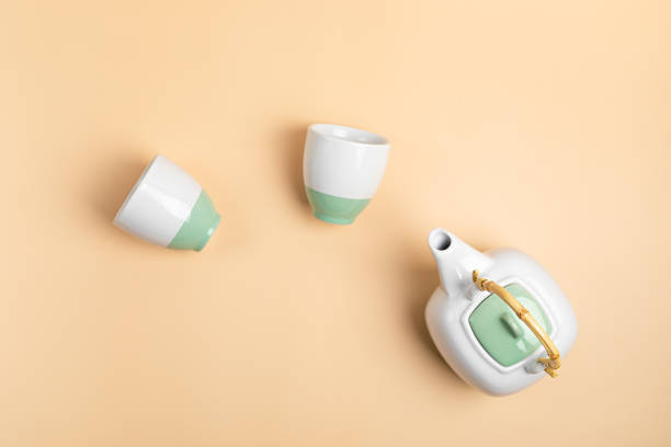 istock White ceramic tea pot with cups on pastel background. Eco friendly organic brand concept. Branding mockup. Flat lay 1296704691