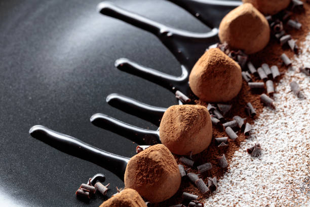 istock Chocolate truffles on a black plate with chocolate sauce. 1296707356