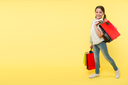 Great school shopping deals. Back to school season great time to teach budgeting basics children. Girl carries shopping bags. Prepare for school season buy supplies stationery clothes in advance.