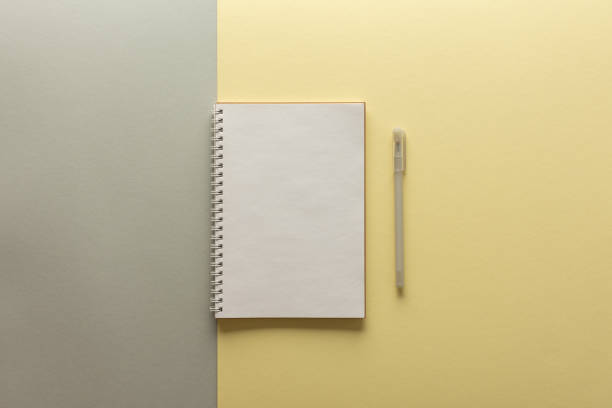 istock Open spiral notepad on gray and yellow background 1296709763