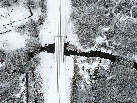 aerial view of winter landscape with railway crossing the river covered with snow. drone photography. Russian winter landscape. top view