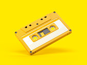 Yellow vintage audio cassette on yellow background.