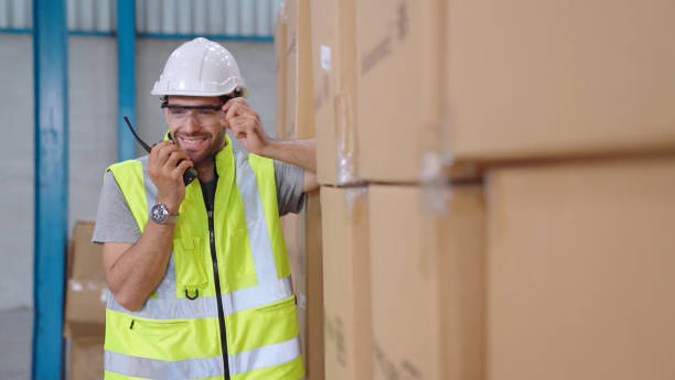 istock Professional cargo worker talks on portable radio to contact another worker 1296714522