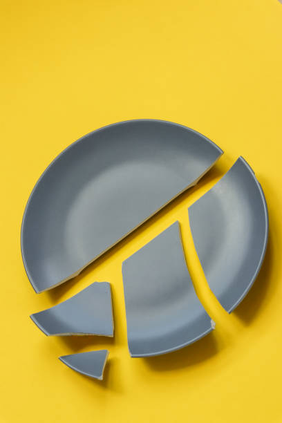 broken gray ceramic plate on yellow background. - pottery shard imagens e fotografias de stock