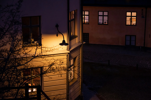 Warm street lighting. cozy narrow European street. Stockholm, Sweden. Cobbled street in Sodermalm.