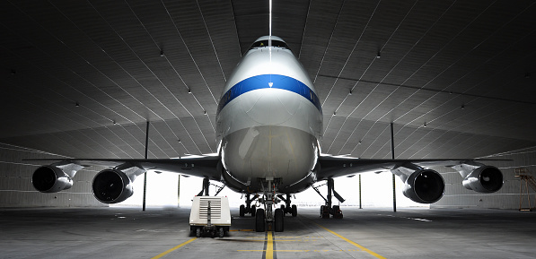Airplane parking in a hanger inside airport . Elements of this image furnished by NASA . https://nasasearch.nasa.gov/search/images?affiliate=nasa