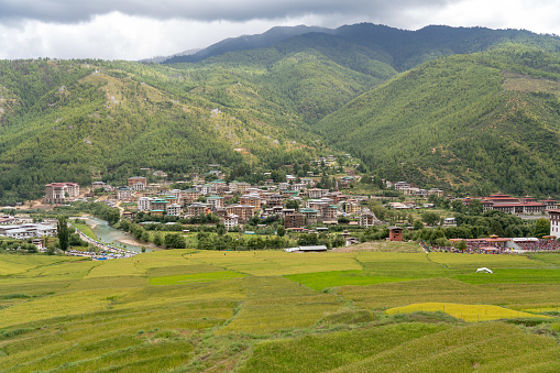 Paro, Bhutan: Paro Chu Valley, Paro town and Jangsa (bottom) and Wang Chu valley (center) seen from the air - Paro Chu river and the town center - town in western Bhutan in the Paro District with around 15,000 inhabitants, located on the  Phuntsholing to Thimphu road at an altitude of around 2400 m, known for Paro International Airport. The area on the north bank of the Paro Chu river is called Jangsa.