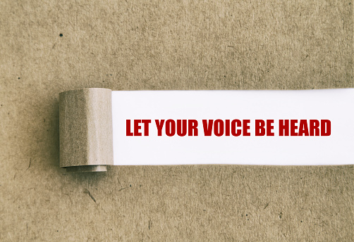 Let your voice be heard written under torn paper.