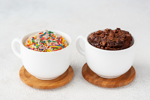 Two mug cakes, light and dark, stands together on a table