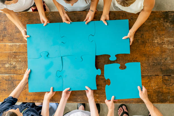 istock Aerial view of hands on puzzle pieces together 1296719714