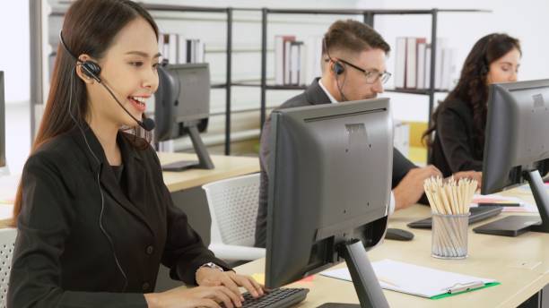 istock Business people wearing headset working in office 1296720190