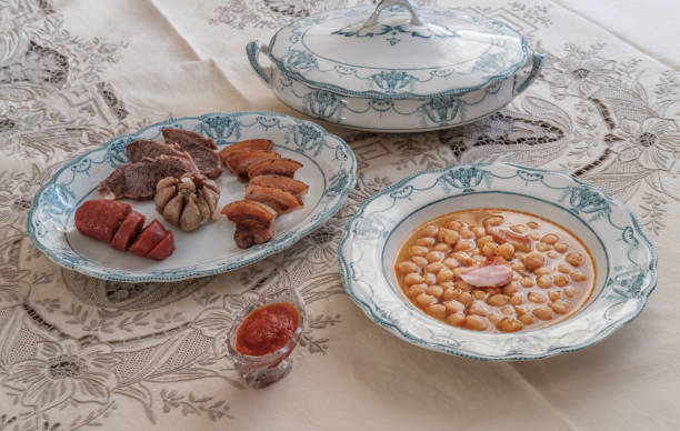 Spanish Chickpea Stew with meat. Elegant crockery. Traditional table. Embroidered tablecloth