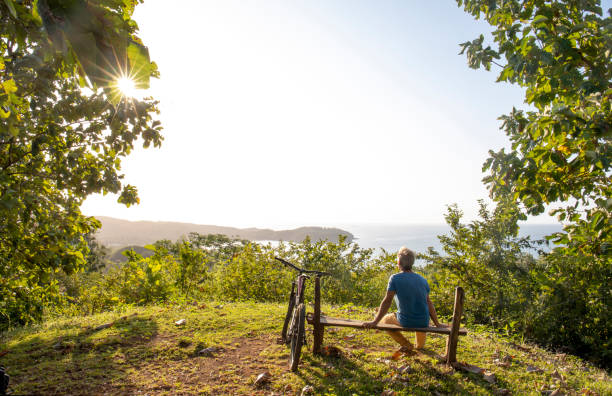 istock Mountain biker relaxes above tropical rainforest in the morning 1296724151
