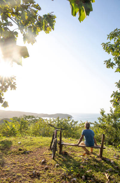 istock Mountain biker relaxes above tropical rainforest in the morning 1296724182