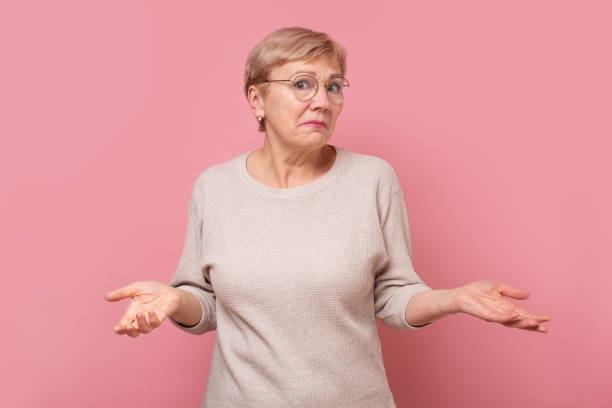 Senior caucasian woman being clueless and confused with arms and hands raised. stock photo