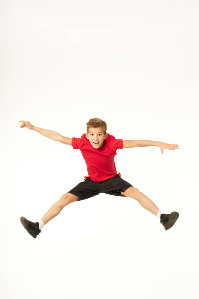 istock Cheerful cute boy in sportswear jumping in studio 1296731000