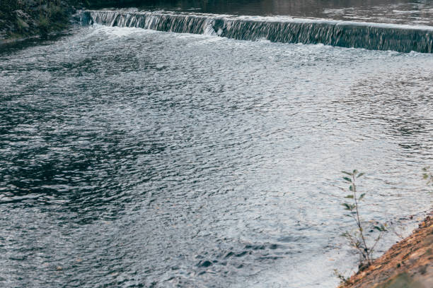 istock Wide river on summer day. Water flow on dam 1296732066