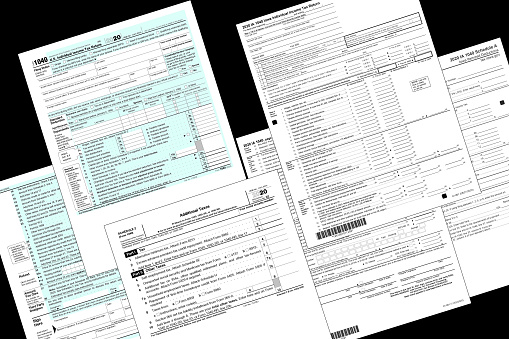 2020 IRS and State of Iowa tax forms lay on a black desktop.