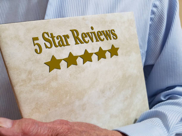 Five Star Reviews. Man holds book entitled 5 Star Reviews. consumer confidence photos stock pictures, royalty-free photos & images