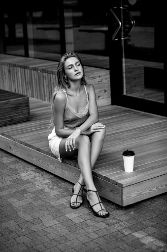 Beautiful girl outdoors with cup of coffee