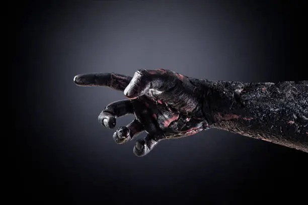 Creepy zombie hand over dark background with clipping path