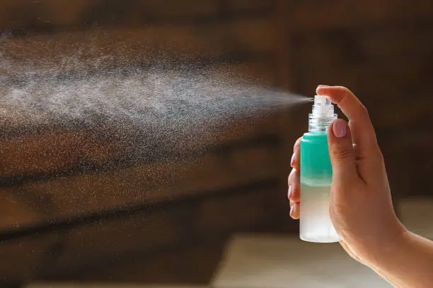 Photo of A woman hand spraying hydrating spray