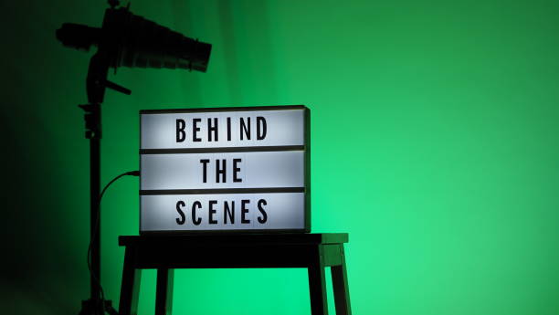 istock Cinema Light box. Behind the scenes letterboard text on Lightbox. Multi color LED on background. Sillhouette flash snoot hood on tripod. video production studio. Behind the scene Lightbox 1296735558