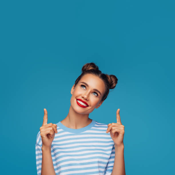 istock Beautiful girl pointing up presenting your product 1296735885