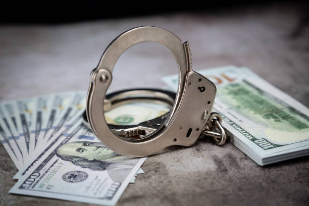 istock Handcuffs on $100 Bills on Concrete Floor for Crime or DUI 1296738510