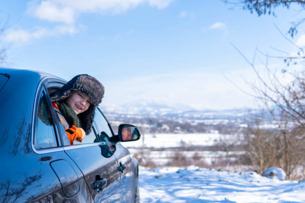 istock little boy looking through the car window, going on a winter road trip 1296740560