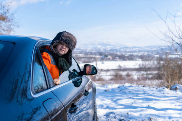 istock little boy looking through the car window, going on a winter road trip 1296740583