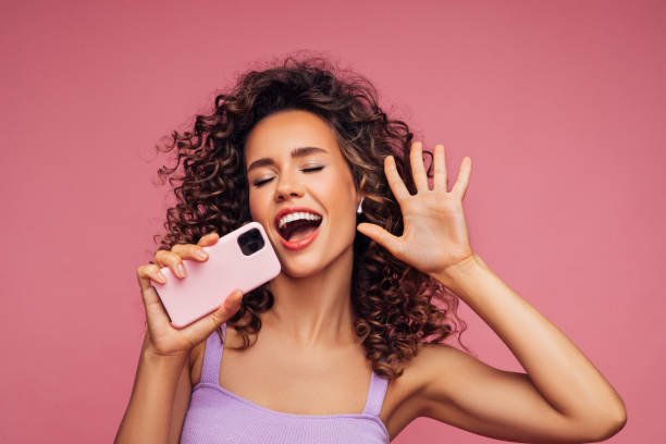 istock Woman holding smartphone and singing 1296745142