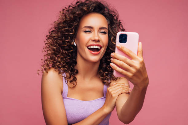 istock Woman in wireless earbuds making selfie 1296745176