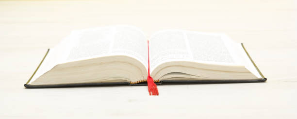 istock Open book against white wooden background with copy space for ad text. Education back to school concept 1296746899