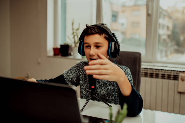 istock Boy attending online classes from home. Child using laptop and headsets for connecting with teacher and schoolmates. School education and social distance during quarantine 1296748986