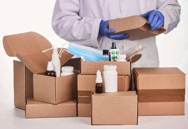 istock Pharmacist collecting medications and packing them into cardboard parcels 1296751213