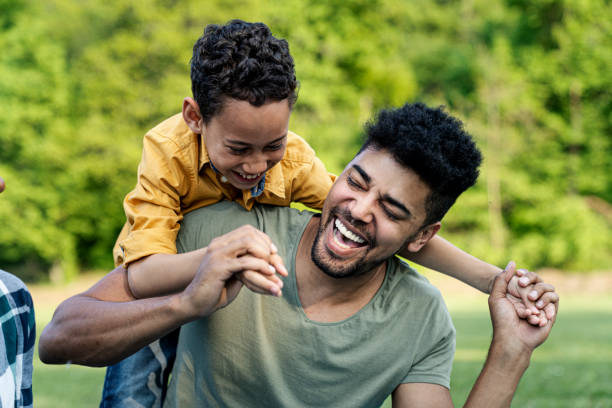 beztroski chłopiec bawi się z ojcem w parku - outdoors playing family spring zdjęcia i obrazy z banku zdjęć