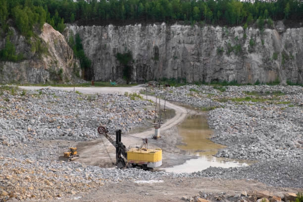 istock Yellow truck inside granite quarry. Mining equipment, industry, mining 1296754637