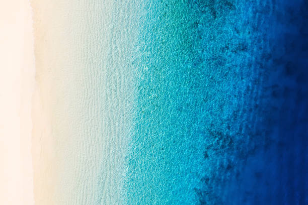 istock Waves as a background from top view. Azure water background from drone. Summer seascape from air. Gili Meno island, Indonesia. Travel and vacation image 1296756875