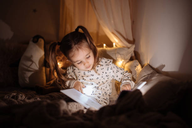 아름다운 어린 소녀 독서 책 누워 에 침대 - 한 소녀만 뉴스 사진 이미지