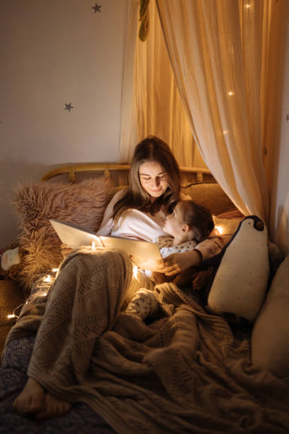 寝る前にベッドで本を読む母子 - child reading mother book ストックフォトと画像