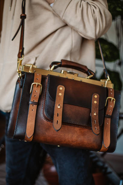 istock Business man holding elegant brown leather briefcase. 1296761541