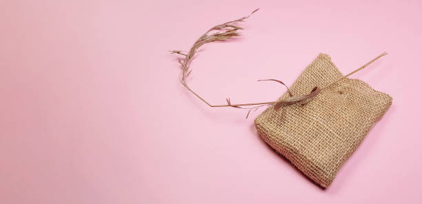istock Dry grass and canvas bag for composition, on pink background, DIY concept, top view 1296761591