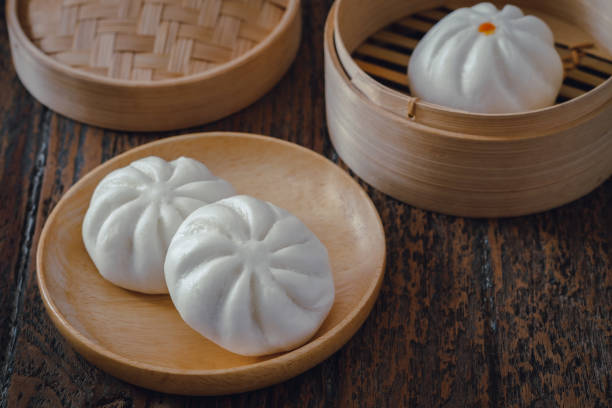 istock Steamed pork buns on wooden plate, Chinese dim sum 1296761789
