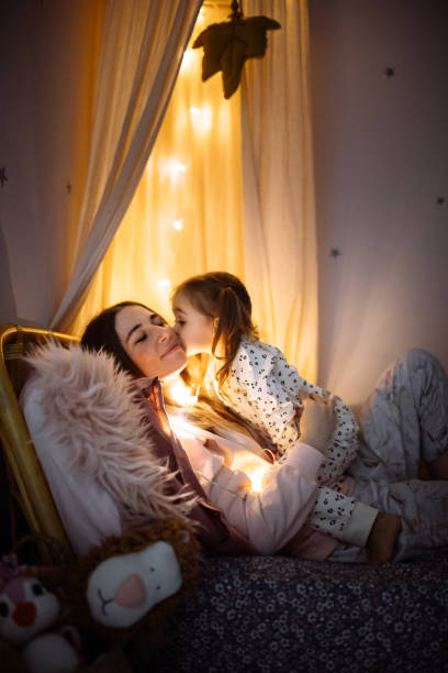 istock Happy mom lying with her baby daughter on bed 1296762994