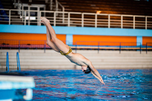 istock Professional male swimmer jumping into the watter 1296767169