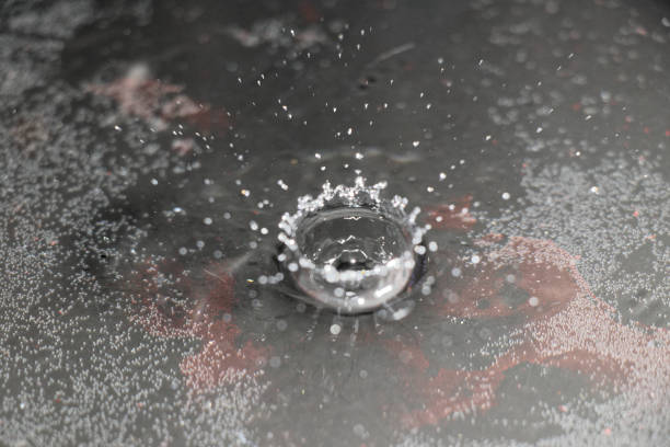 istock Water Drop Hits Surface and Creates Wonderful Splash and Bokeh 1296772444
