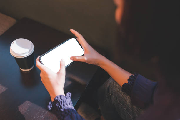 istock Closeup of woman using smartphone blank screen with clipping path in cafe 1296775939